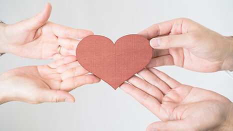 ハートを持つ2人の手
