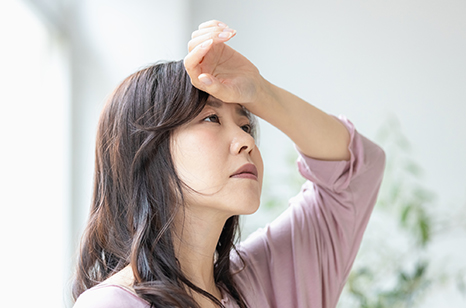 額に手をやる女性
