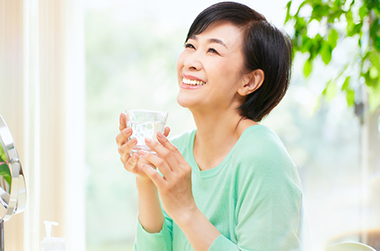水の入ったグラスを持つ女性